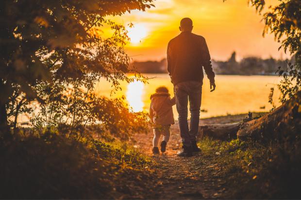 South Wales Argus: Father and child walking together at sunset. Credit: Canva
