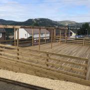 The pergola, wooden posts, at the front of this decking will have to removed along with most of the decking in front of the first post nearest to the property.