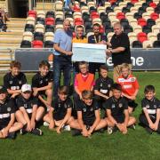 Smile Council members Chris Thomas, Andrew Lloyd and Aaron Thomas present Darren Broadribb and academy players with a cheque for £2,500