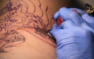 A stock image of a tattoo artist at work.